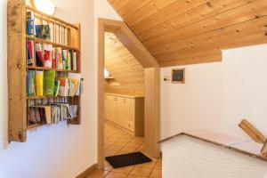a hallway with a book shelf filled with books at Oberwieserhof App 1 in San Lorenzo di Sebato