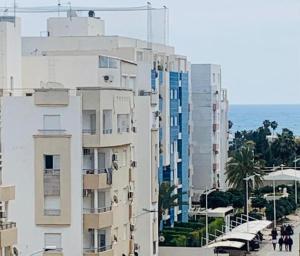 a group of tall buildings next to the ocean at L'APPARTEMENT PARADISIAQUE A HAMMAMET ET NABEUL in Nabeul