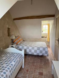 a bedroom with two beds and a window at Manoir de Valette in Chartrené