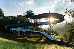 - un toboggan dans un parc aquatique avec le soleil derrière dans l'établissement Gooderson Leisure Natal Spa Self Catering and Timeshare Resort, à Paulpietersburg