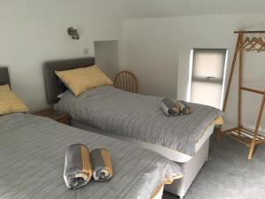 a bedroom with two beds and a mirror at Kings Cottage, Nairn - a charming place to stay in Nairn