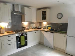 a kitchen with white cabinets and a green towel on the oven at Kings Cottage, Nairn - a charming place to stay in Nairn