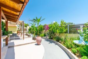 a garden with a swimming pool in a house at Sunset Apartments Free shuttle from Athen's Airport in Spáta