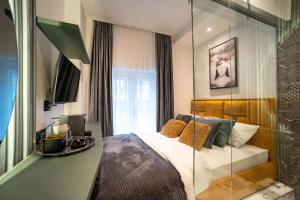 a bedroom with a bed and a glass wall at Natali luxury suites- mini rooms in Belgrade