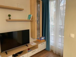 a living room with a flat screen tv and a window at Уютен апартамент на 3 мин. от главната и Капана +паркинг in Plovdiv