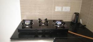 a black stove top with two tea pots on it at Lovely 1bedroom compact condo at 9th floor in Kelambākkam +9 photos