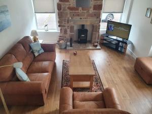 a living room with a couch and a tv at Kings Cottage, Nairn - a charming place to stay in Nairn
