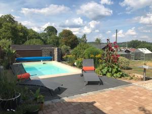 a swimming pool with two lawn chairs and a swimming pool at APARTMENT SONNE Reusa in Plauen