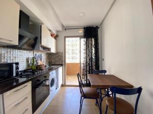 a kitchen with a table and a dining room at L'APPARTEMENT PARADISIAQUE A HAMMAMET ET NABEUL in Nabeul