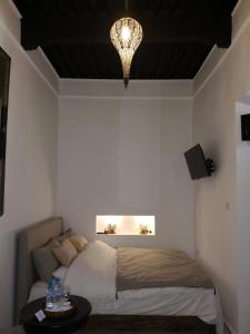 a bedroom with a bed and a chandelier at Riad de charme l'Oasis d'Essaouira - Chambre Luxe in Essaouira