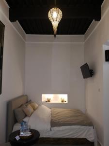 Un dormitorio con una cama y una lámpara de araña. en Riad de charme l'Oasis d'Essaouira - Chambre Luxe, en Essaouira