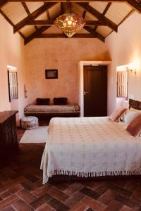 una camera da letto con un letto grande e un divano di Beautiful Accommodation At The Heart Of Andalusia a Puente Genil