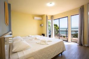 a bedroom with a bed with a view of the ocean at Hotel Vila Mar in Florianópolis