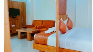 1 dormitorio con 1 cama, 1 silla y TV en Hotel Dc Star, en Tarapith