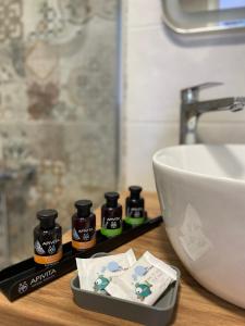 eine Badezimmertheke mit einem Waschbecken und 4 Flaschen Seife in der Unterkunft «ΑΓΝΑΝΤΙΟ l» Δωμάτιο με μοναδική θέα! in Mirina