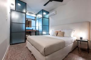 een slaapkamer met een groot wit bed en glazen wanden bij Hidesign Athens The Getaway Apartments in Athene