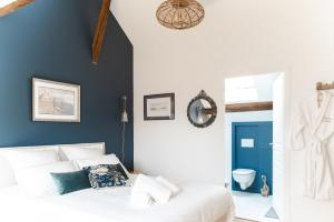 a bedroom with a white bed and a blue wall at Domaine de Jouarre in Jouarre