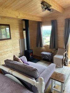 a bedroom with a bed and a stove in a room at Cosy cabin in Annie’s meadow in West Meon