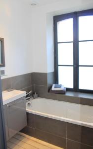 La salle de bains est pourvue d'une baignoire, d'un lavabo et d'une fenêtre. dans l'établissement Maison vue exeptionnelle sur la mer, à Lancieux