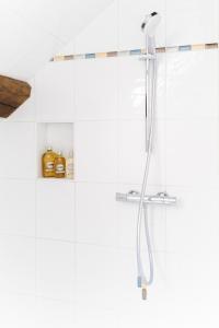 a shower in a bathroom with white tiles at Domaine de Jouarre in Jouarre