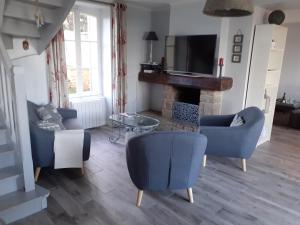 un salon avec des chaises bleues et une cheminée dans l'établissement Maison vue exeptionnelle sur la mer, à Lancieux