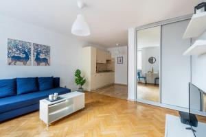 ein Wohnzimmer mit einem blauen Sofa und einem Tisch in der Unterkunft Śliska 10 Prywatne mieszkanie 300m od Dworca Centralnego oraz metra ONZ in Warschau
