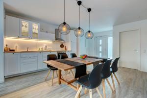 a kitchen and dining room with a wooden table and chairs at Bernsteinquartier BQ 10b in Kolpinsee