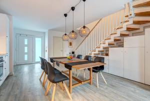 a dining room with a table and chairs and a staircase at Bernsteinquartier BQ 10b in Kolpinsee