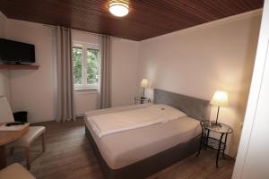 a bedroom with a bed and a desk and a tv at Hotel Central in Zeven