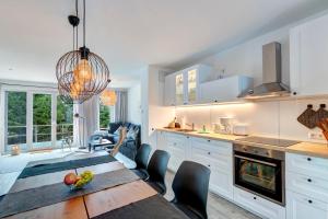 a kitchen and dining room with a table and chairs at Bernsteinquartier BQ 10b in Kolpinsee