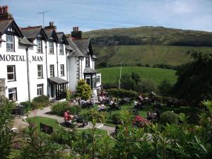 een groep mensen die buiten een gebouw zitten bij The Mortal Man Inn in Troutbeck