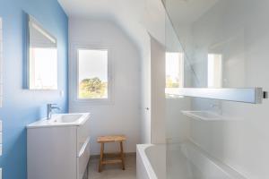 uma casa de banho branca com um lavatório e uma banheira em La Grande Plage em Saint-Cast-le-Guildo