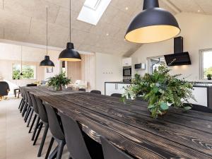 a long wooden table with chairs and pendant lights at 20 person holiday home in Højslev-By Traum in Højslev