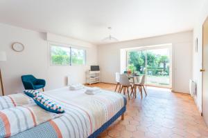 Un dormitorio con una cama y una mesa con sillas. en Le Jardin des Dunes, en Saint-Cast-le-Guildo