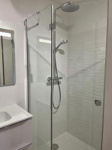 una ducha de cristal en un baño con lavabo en Le Jardin des Dunes, en Saint-Cast-le-Guildo