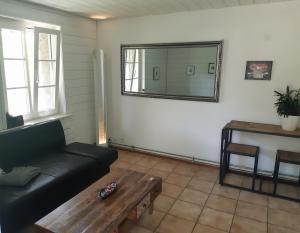 a living room with a black couch and a mirror at Aareggli in Bern