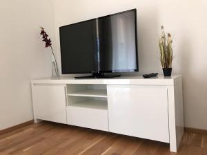 a white entertainment center with a television on it at Apartment Seenah Zentral in Pörtschach am Wörthersee