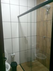 a bathroom with a glass shower with a toilet at Recanto Bela Vista serra in Tiradentes