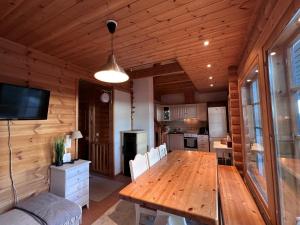una sala da pranzo con tavolo in legno e una cucina di Kotamäki B a Syöte