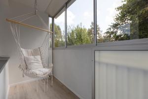 een hangmat in een kamer met een raam bij Warsaw Stawki Cosy Apartment by Renters in Warschau
