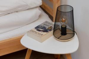 een boek en een lamp op een tafel naast een bed bij Warsaw Stawki Cosy Apartment by Renters in Warschau