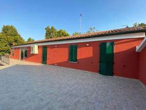 un edificio rojo con puertas verdes y entrada en Ca Rossa, en Bondeno