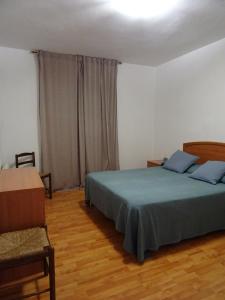 a bedroom with a green bed and a chair at Pis Acollidor amb LLar de Foc, al Centre Camprodon in Camprodon