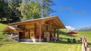una baita su una collina con un ombrellone di Ferienhütte Sternenblick a Grosskirchheim