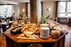 einen Tisch mit einem Buffet mit Speisen und Tellern darauf in der Unterkunft Hotel Westerkamp in Osnabrück