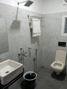 uma casa de banho com um lavatório e um WC em VIAN INN em Guwahati