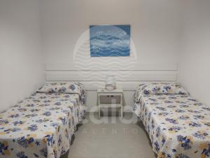 トッレ・ラピッロにあるVilla Mariposa n°3のベッドルーム1室(ベッド2台、小さなテーブル付)