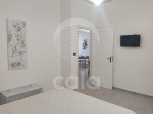 トッレ・ラピッロにあるVilla Mariposa n°3の白いドアとテレビが備わる白い部屋
