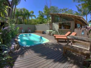 a backyard with a swimming pool and a wooden deck at Pousada El Pátio da Ferrugem uma quadra da praia in Garopaba +18 photos