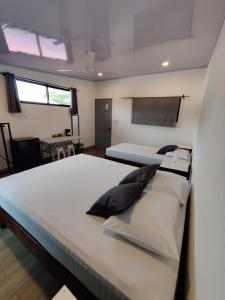 ein großes Schlafzimmer mit 2 Betten und einem Tisch in der Unterkunft Cabinas Maritza in Quebrada Ganado